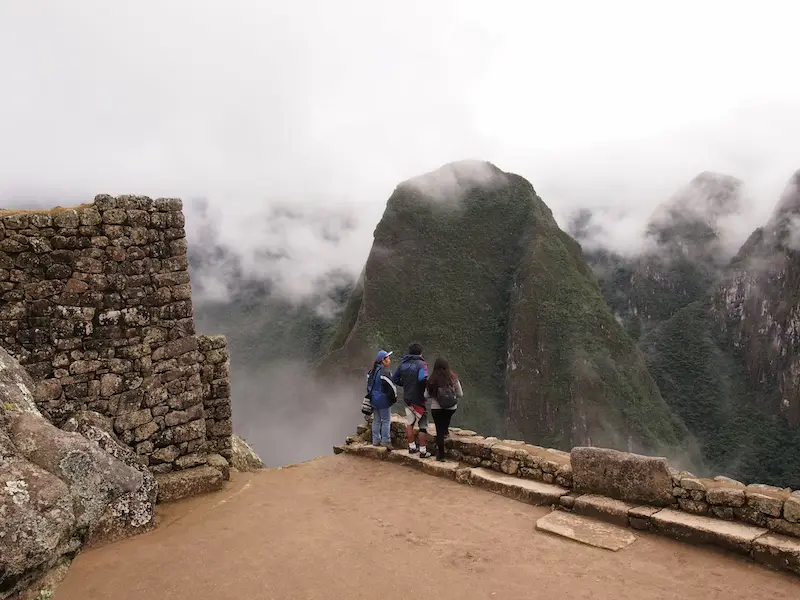 Personas disfrutando su vista en Machu Picchu