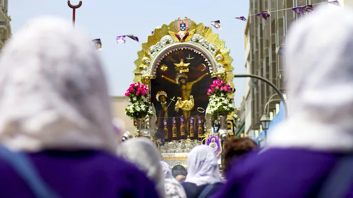 Personas en la procesión cantando el Himno del Señor de los Milagros