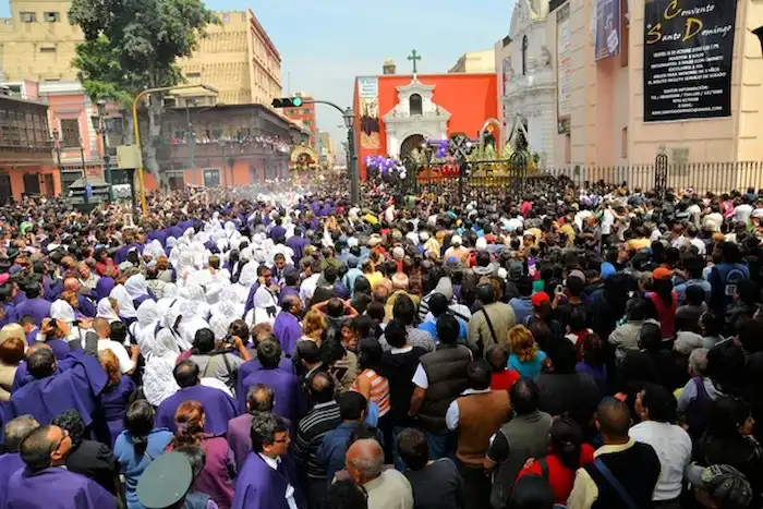Grupo de devotos participando en la procesión por la Festividad del Señor de los Milagros