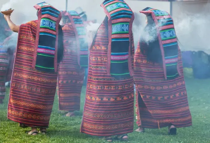 Grupo de personas locales vestidas con vestimenta típica realizando uno de los rituales peruanos